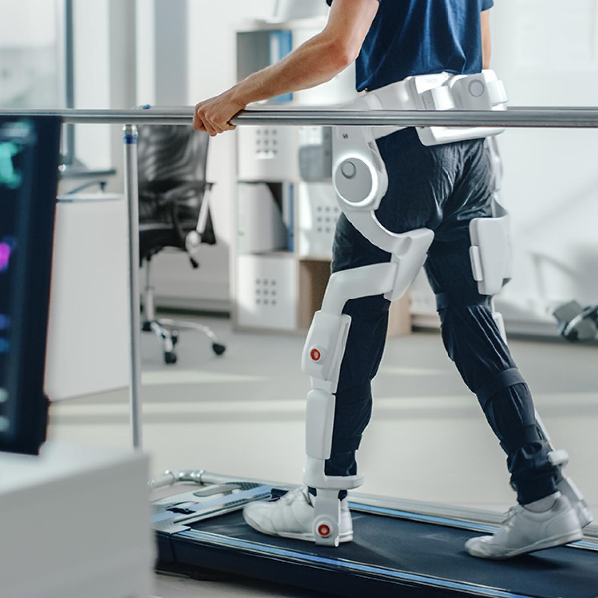 Person walking on treadmill with exterior prosthetics